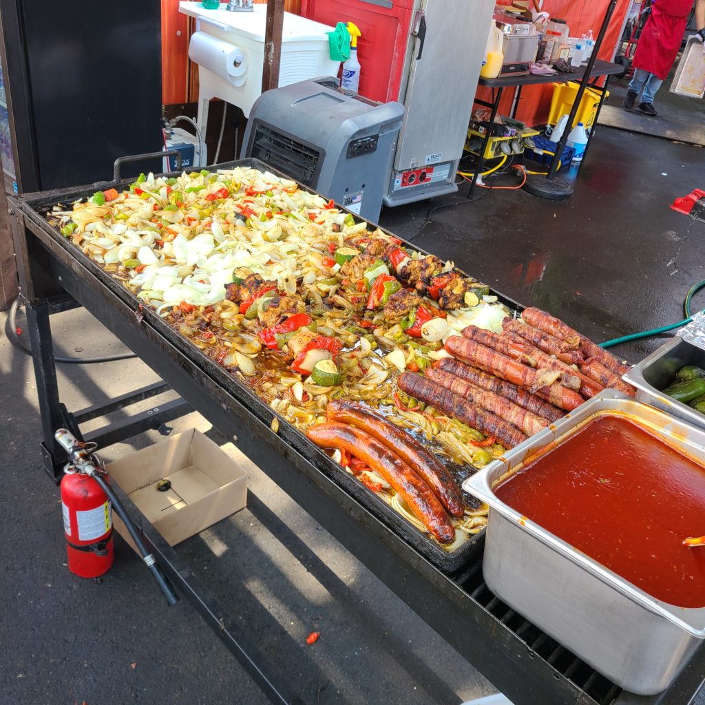 sausages, peppers and onions on a grill